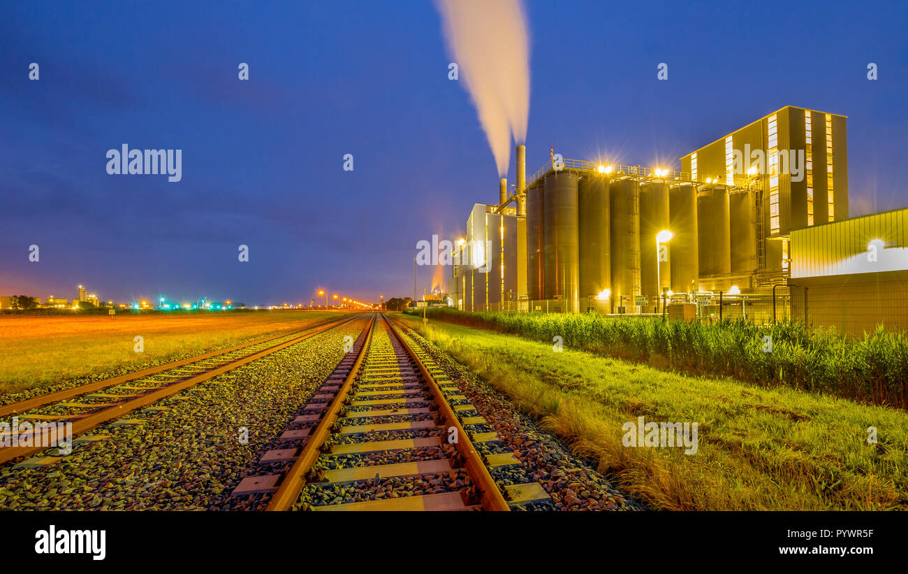 Bunte Panorama der Eisenbahn in einem schweren industriellen chemischen Bereich mit mystischen Verträumten Farben und Licht in der Dämmerung Stockfoto