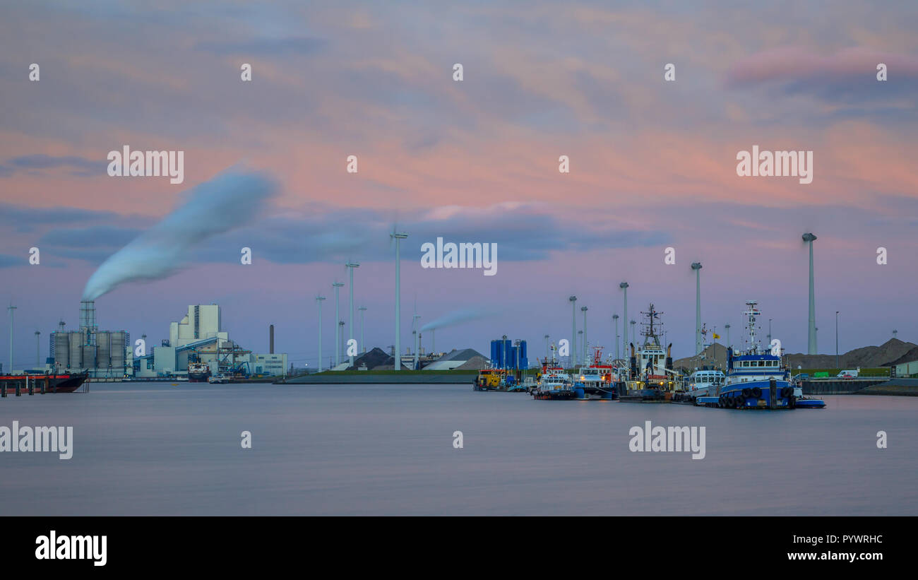 Hafen Eemshaven mit Schiffe am Kai und Schwerindustrie in der Kulisse unter schönen Sonnenuntergang Stockfoto