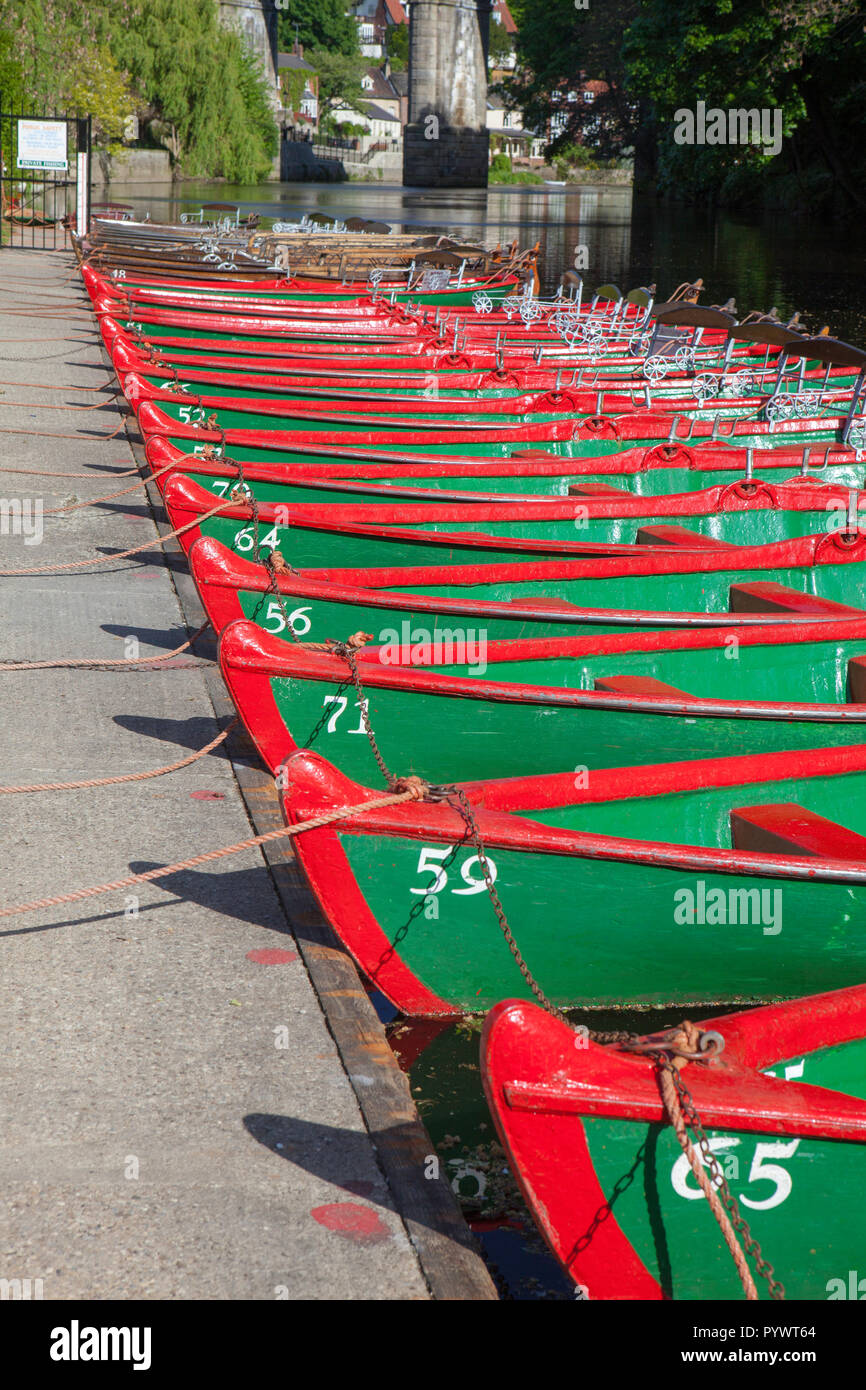 Grün und Rot lackiert rudern Boote aufgereiht am Ufer des Flusses Nidd in Knaresborough, North Yorkshire warten auf Besucher sie auf dem Fluss zu nehmen Stockfoto