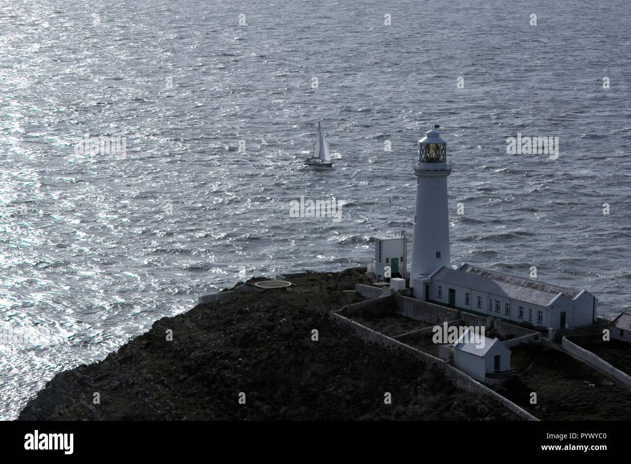 Leuchtturm South Stack auf der wunderschönen walisischen Insel Anglesey. Die Sonne scheint auf den Wellen des irischen Meeres, während dieses dramatische Gebäude Wache steht. Stockfoto