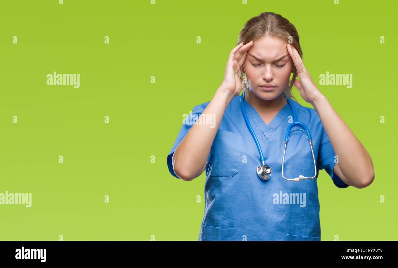 Junge kaukasier Arzt Frau tragen Chirurgen gleichmäßig über isolierte Hintergrund mit der Hand auf den Kopf für Schmerzen im Kopf, weil Stress. Migräne leiden. Stockfoto