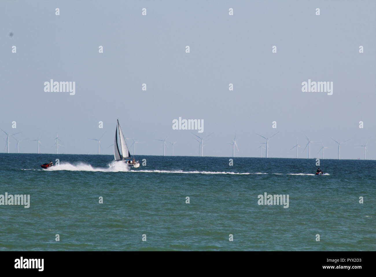 Segelboot und Jet Ski mit Offshore Windpark in den englischen Kanal Stockfoto