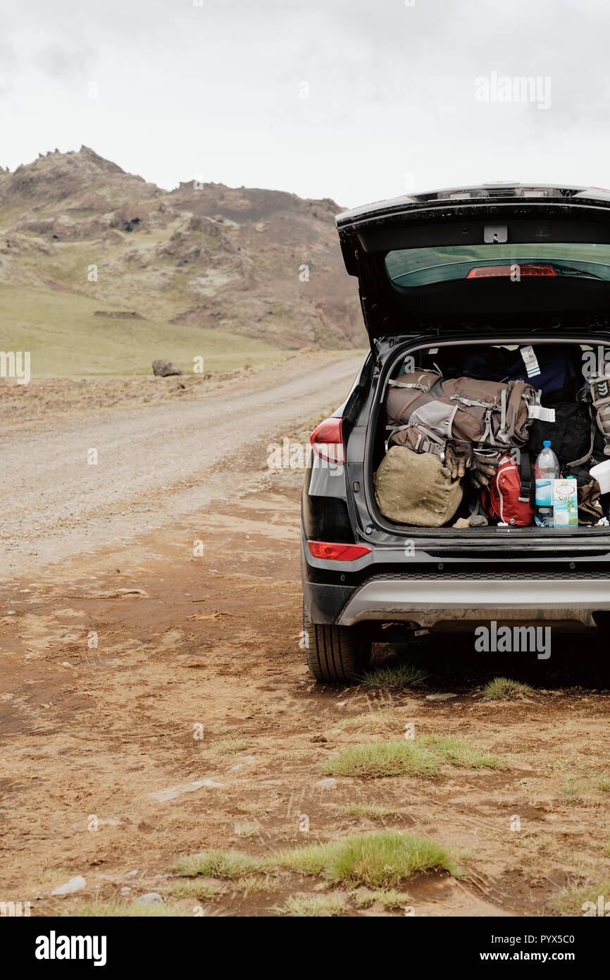 Ein Auto voll gepackt mit Rucksäcken und Camping Ausrüstung, die in der fernen Island Landschaft. Stockfoto
