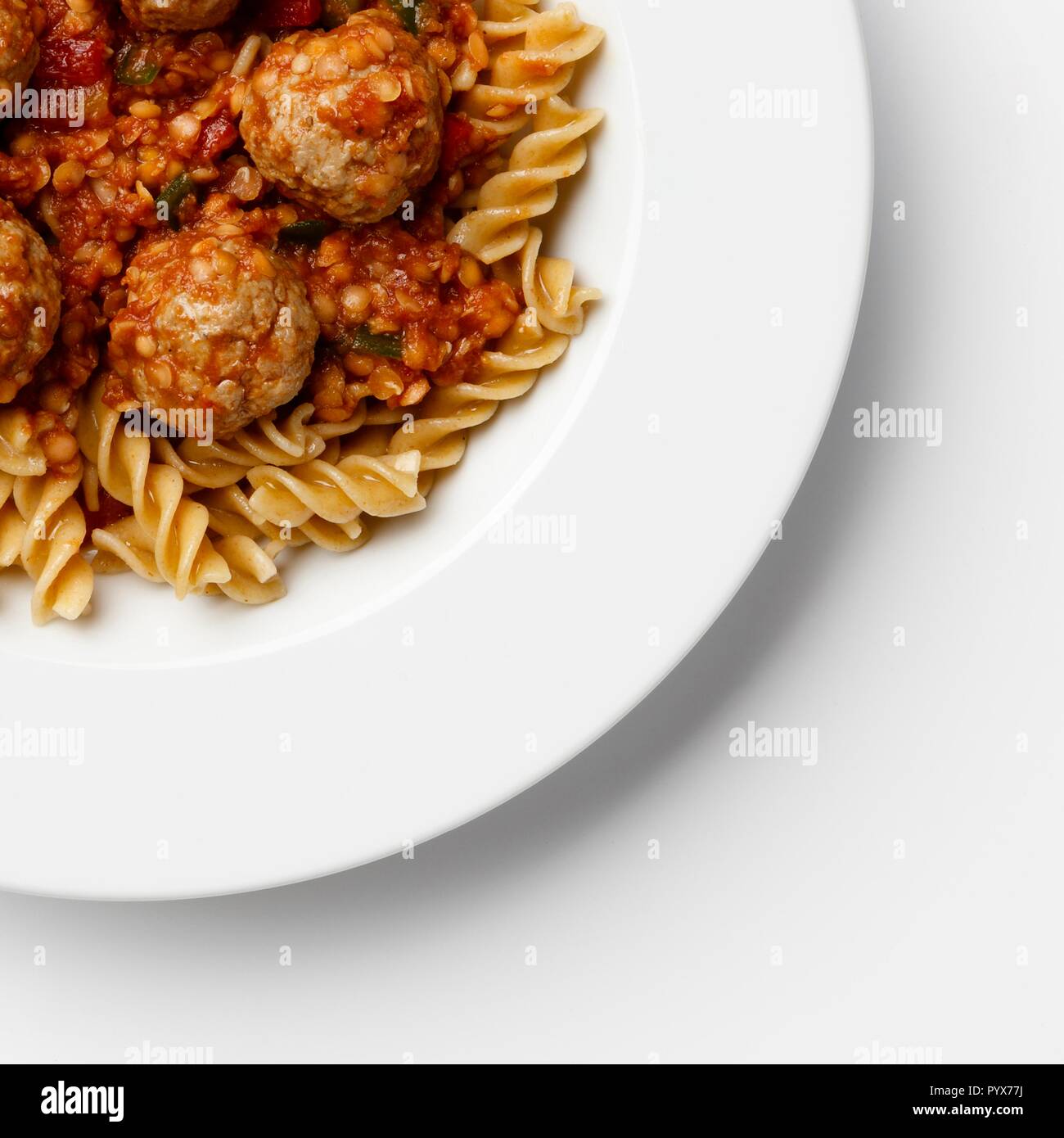 Ecke der Platte auf Fleischbällchen in eine Tomate Sause mit Paste Wendungen, auf einem weißen Hintergrund. Stockfoto