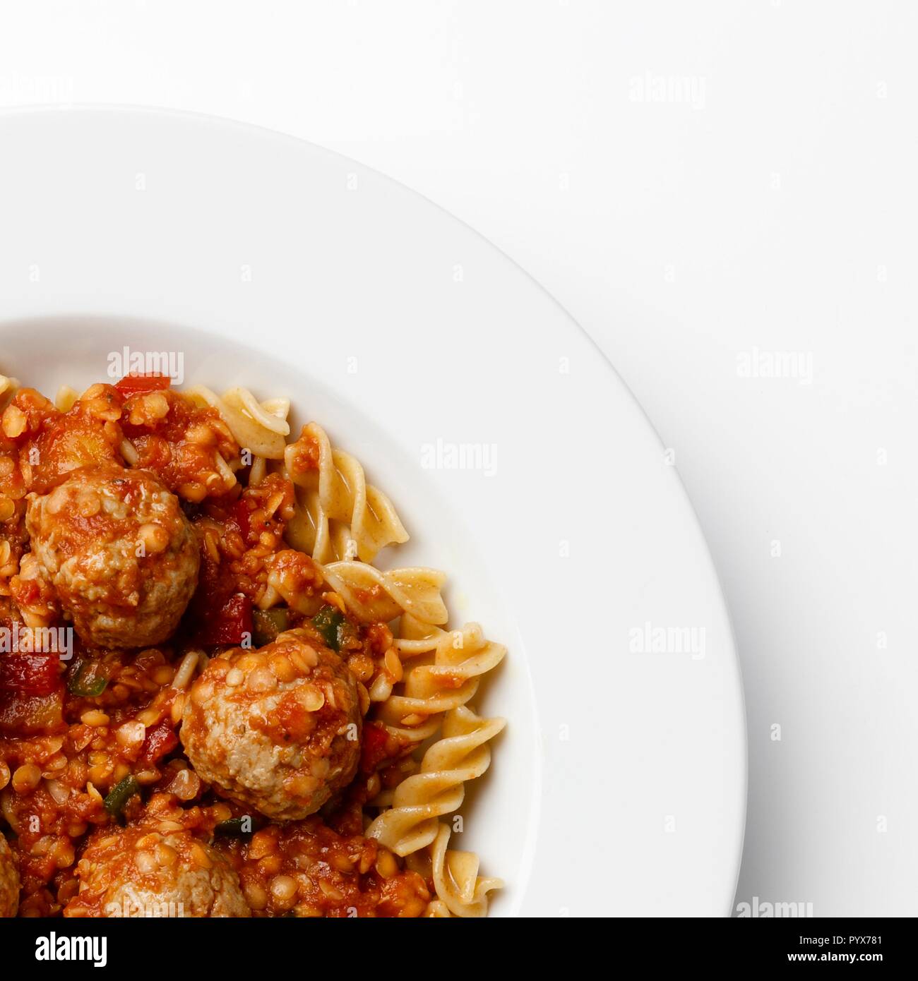 Ecke der Platte auf Fleischbällchen in eine Tomate Sause mit Paste Wendungen, auf einem weißen Hintergrund. Stockfoto