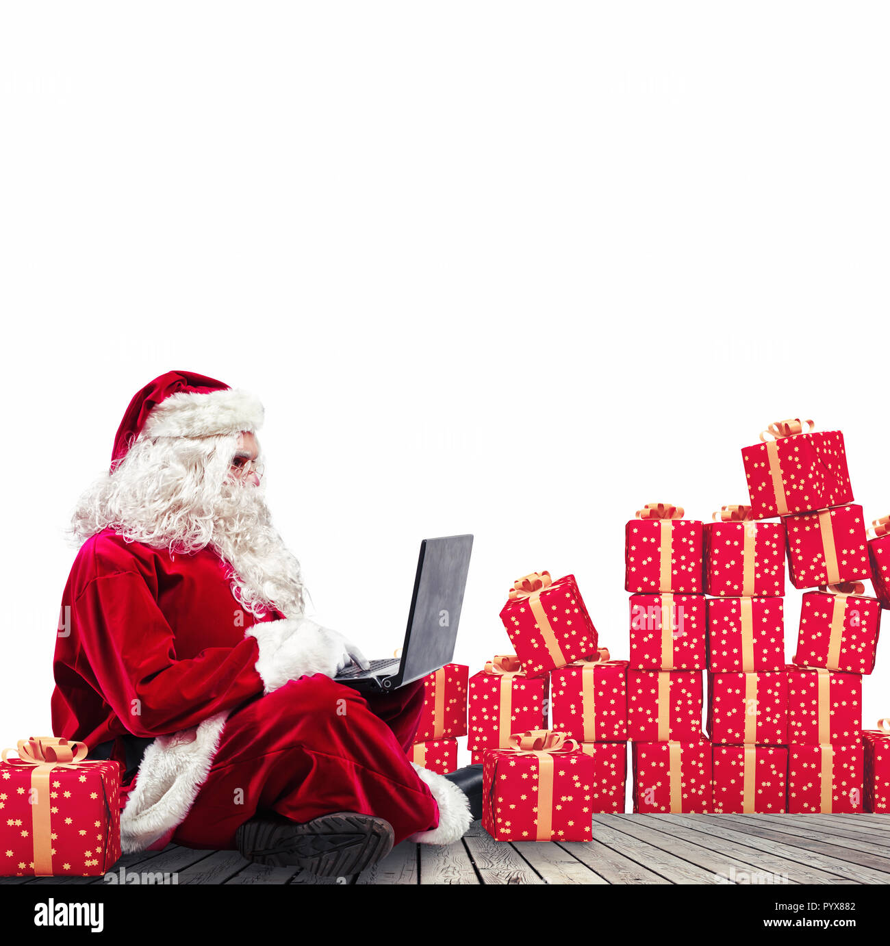 Technologische Santa Claus sitzt mit Laptop kauft Weihnachtsgeschenke mit e-commerce Stockfoto