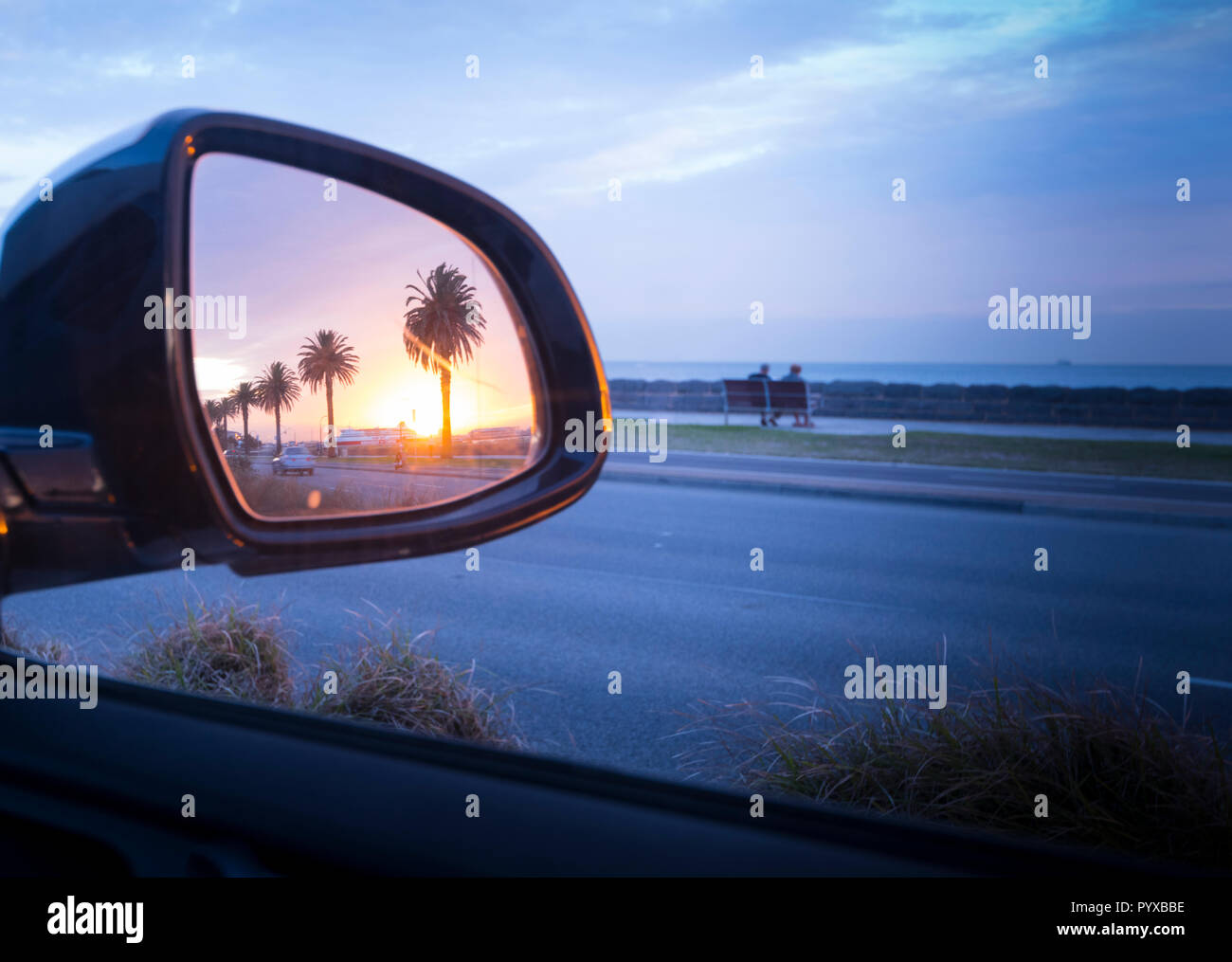 Paar beim Sunset Beach Szene, die gesehen werden können im Rückspiegel des Autos reflektiert werden, Port Melbourne, Victoria, Australien Stockfoto