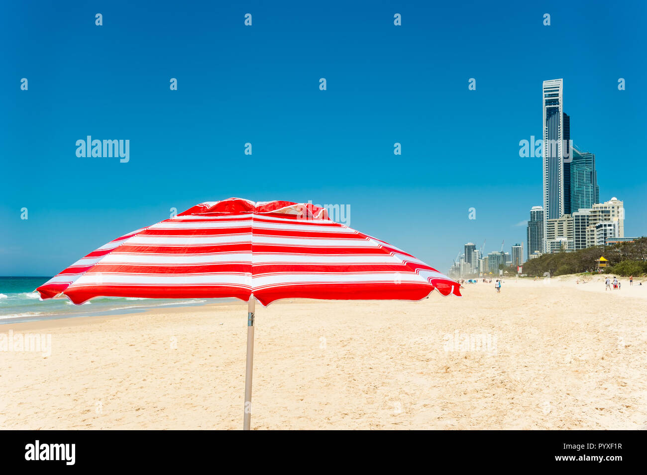 Den wunderschönen weißen Sandstrand, iconic Sonnenschirm und Surfers Paradise City Skyline im Südosten von Queensland. Stockfoto