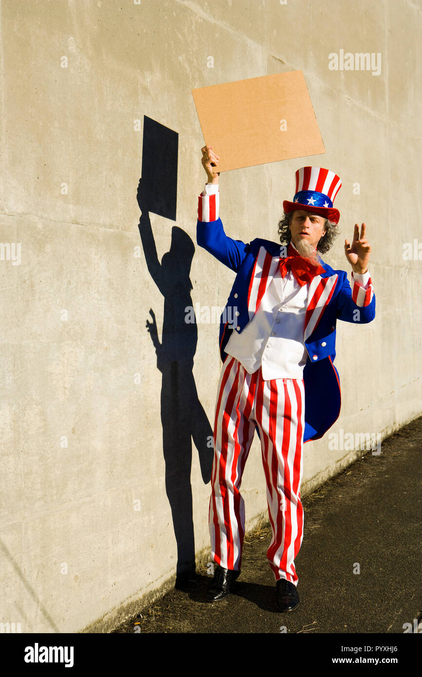 Eine unle SAM-Figur mit einem leeren Zeichen, als ob er Betteln vor. Ihre eigene Nachricht hinzufügen. Stockfoto