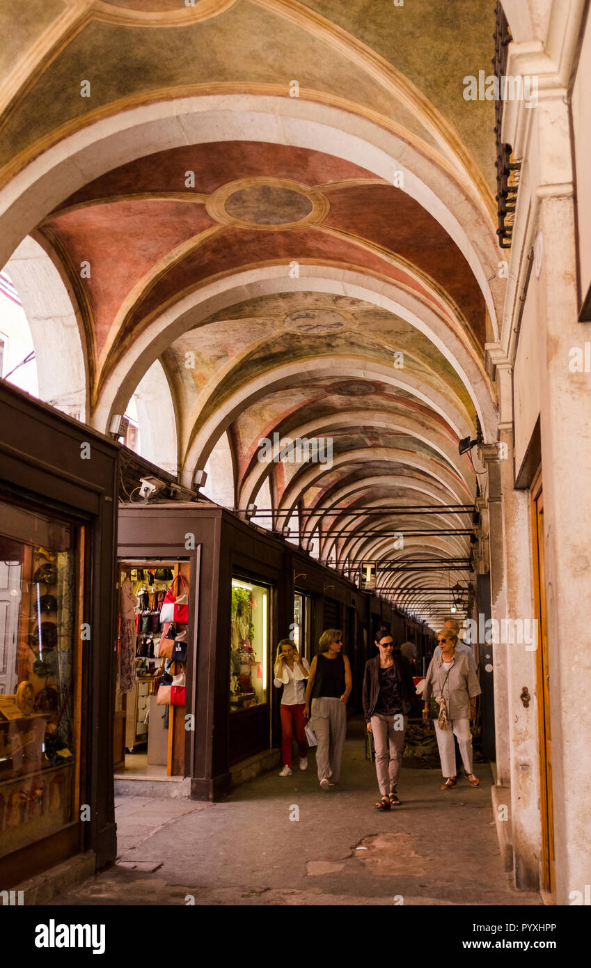 Blick auf den Verblichenen gemalten Szenen in einem gewölbten Arcade über eine Straße in Venedig, Italien Stockfoto