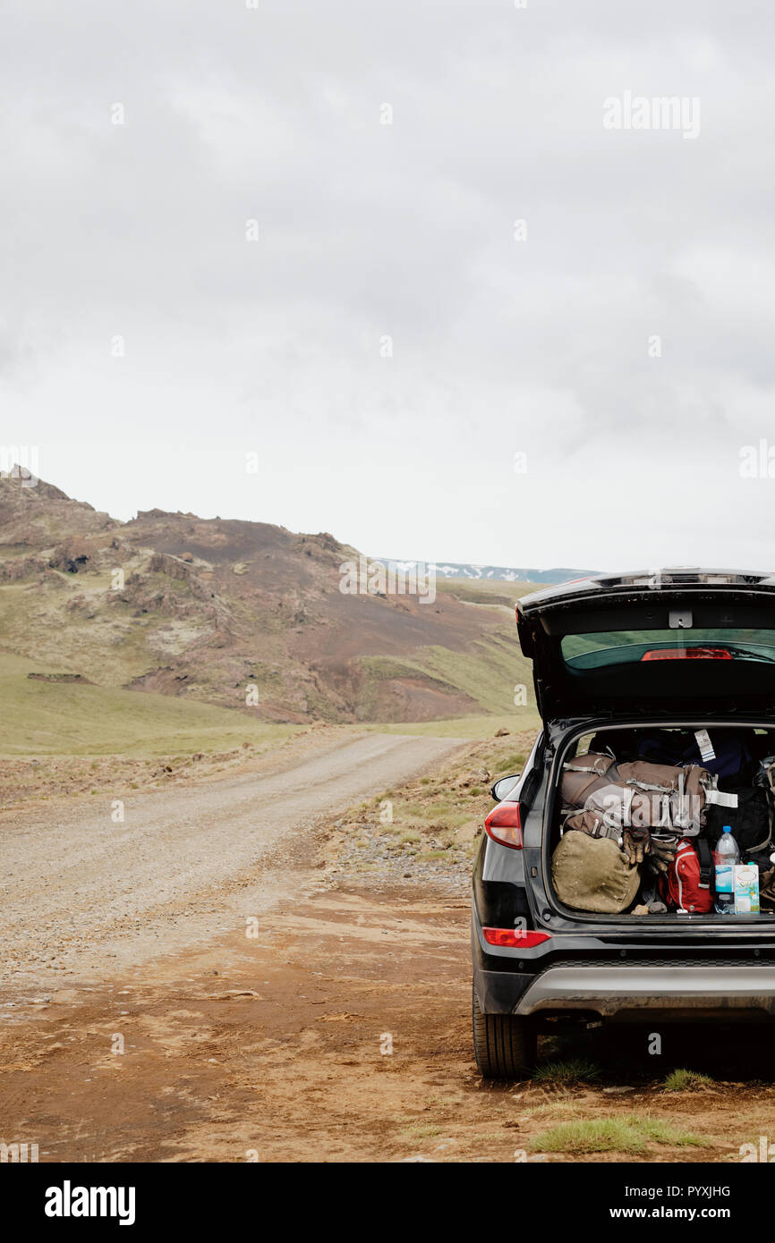 Ein Auto voll gepackt mit Rucksäcken und Camping Ausrüstung, die in der fernen Island Landschaft. Stockfoto
