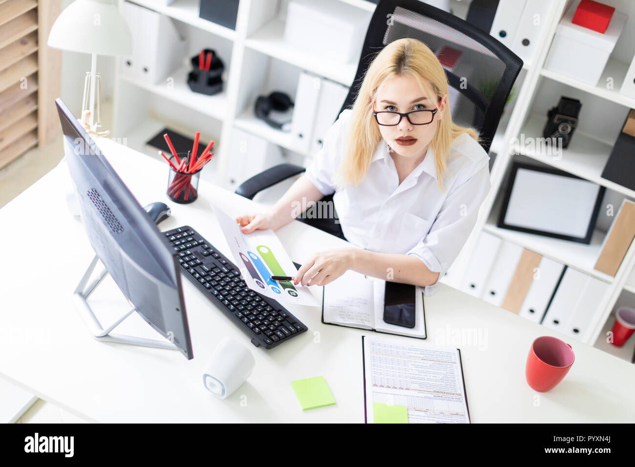 Ein junges Mädchen, die im Büro mit Computer und Dokumente. Stockfoto