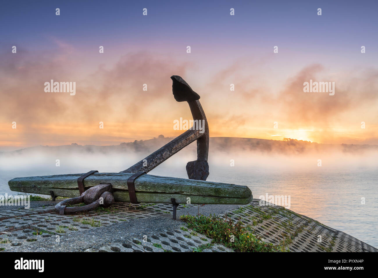 Nach einer kalten Nacht Ende Oktober die Sonne im Nebel steigt hinter der Anker auf der Uferstraße an der malerischen North Devon Dorf Appledore in Stockfoto