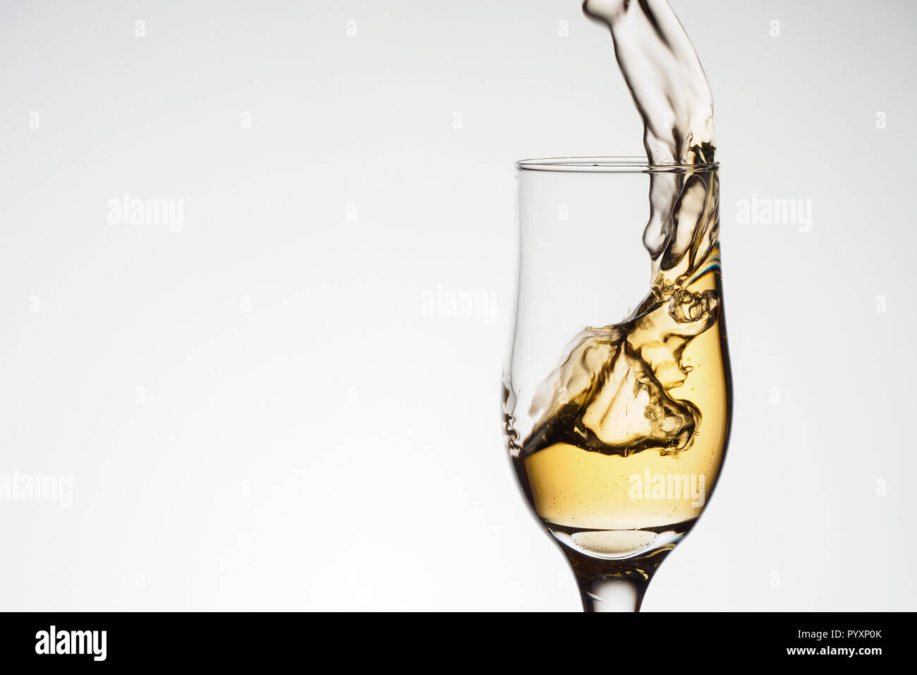 Ein elegantes Glas mit Champagner mit Splash. Urlaub Karte Weihnachten, Neujahr, Hochzeit. Feier Konzept mit Auswirkungen der selektiven Fokus Stockfoto