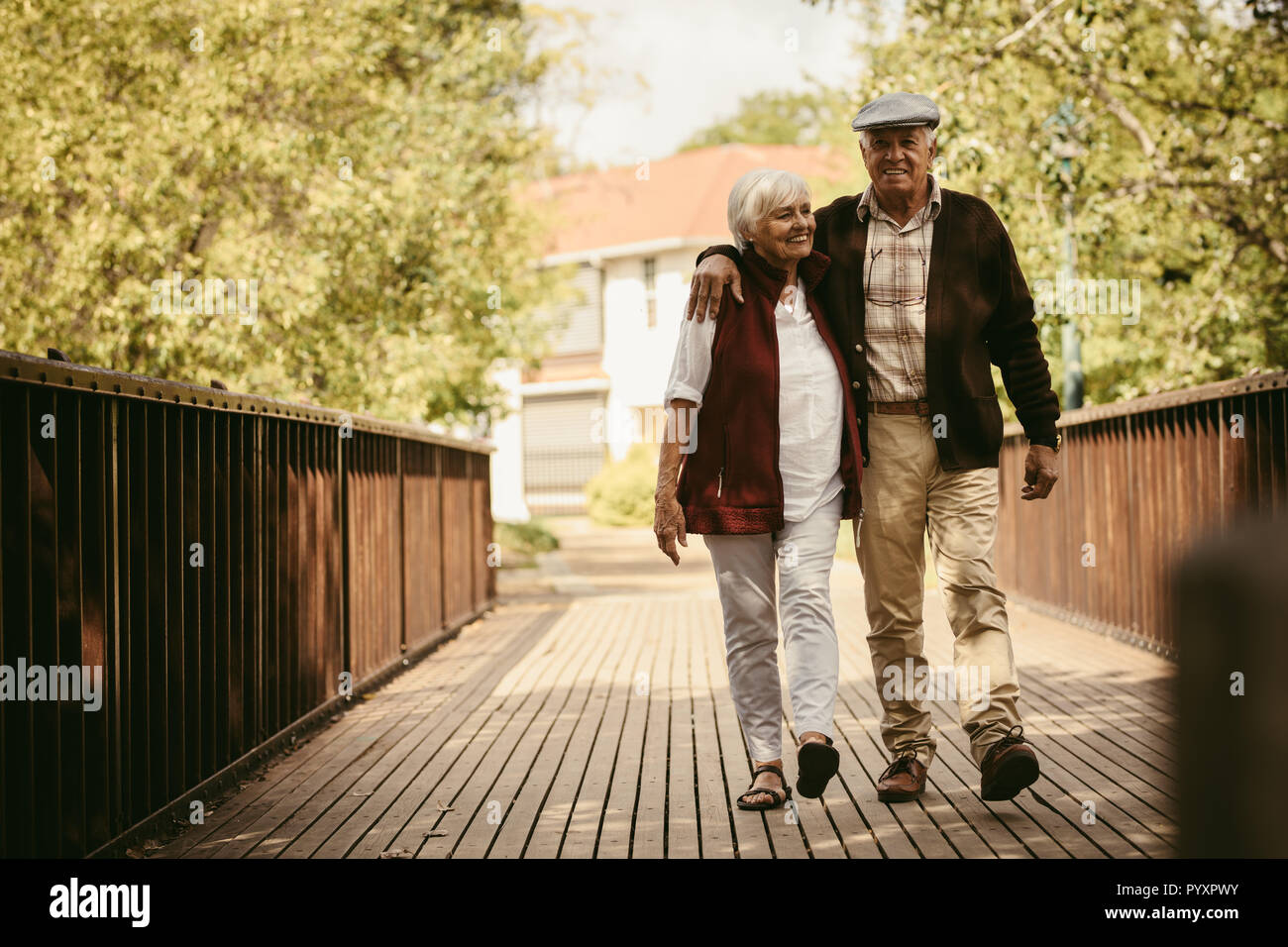 Füllen Länge der gerne ältere Paare gehen durch einen Park. Älterer Mann und Frau zusammen gehen im Park an einem Wintertag. Stockfoto