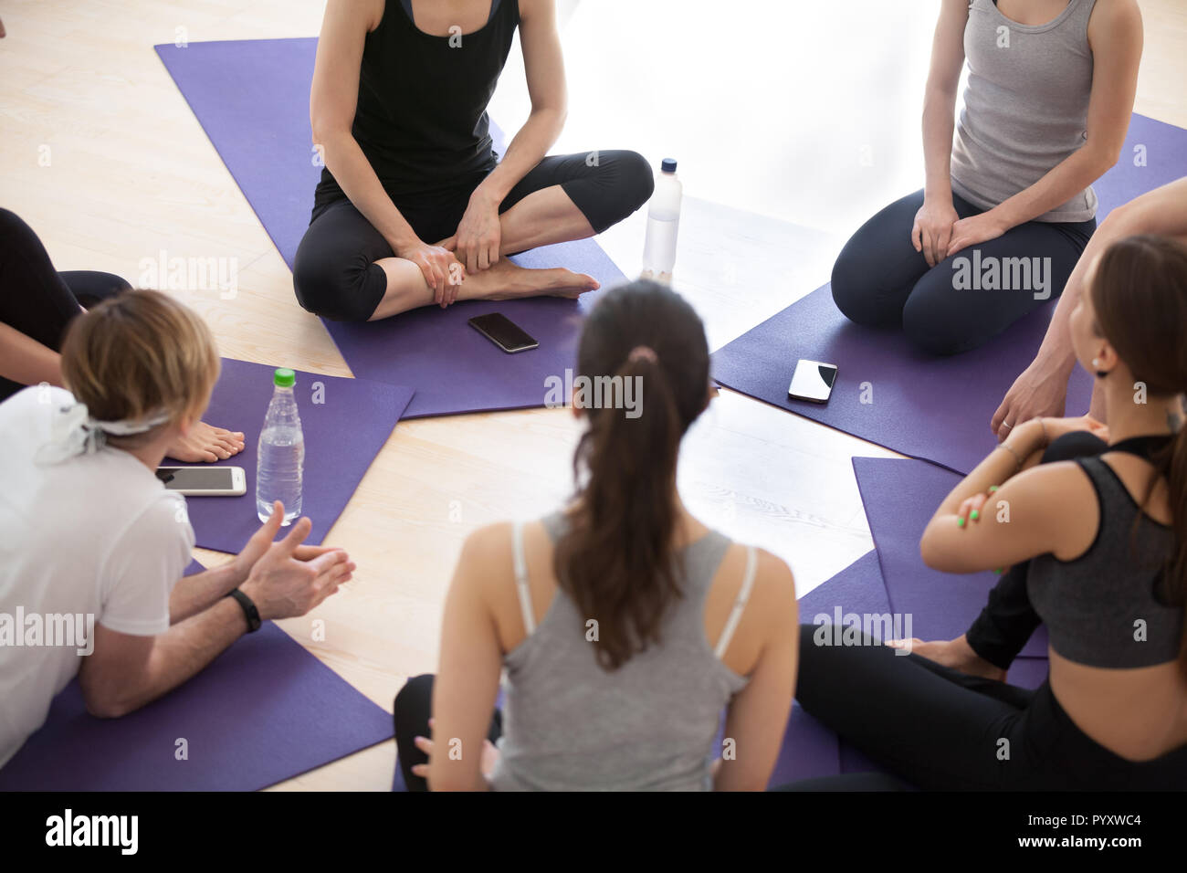 Sportliche Menschen in einem Kreis während des Yoga Seminar Sitzung Stockfoto