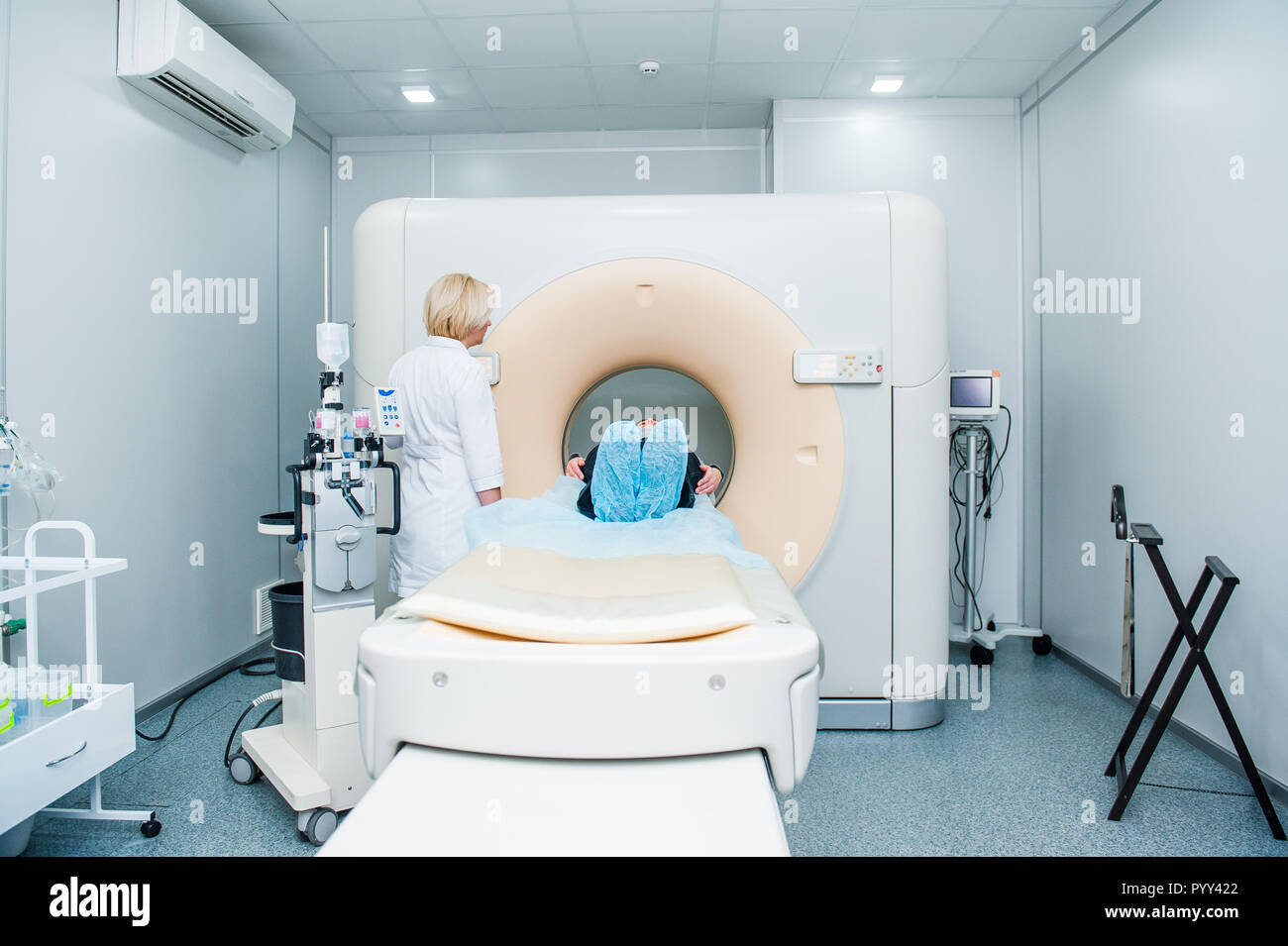 Frau Doktor passt die Computertomographie oder Kernspintomographie Maschine berechnet axial scan mit dem Lügen Patient im Krankenhaus Zimmer Stockfoto