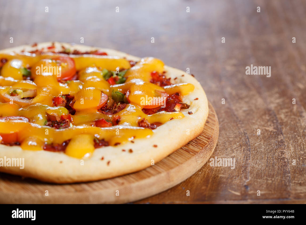 Ein Mini Pizza (oder individuelle oder persönliche Pizza) auf einem Holztisch. Stockfoto