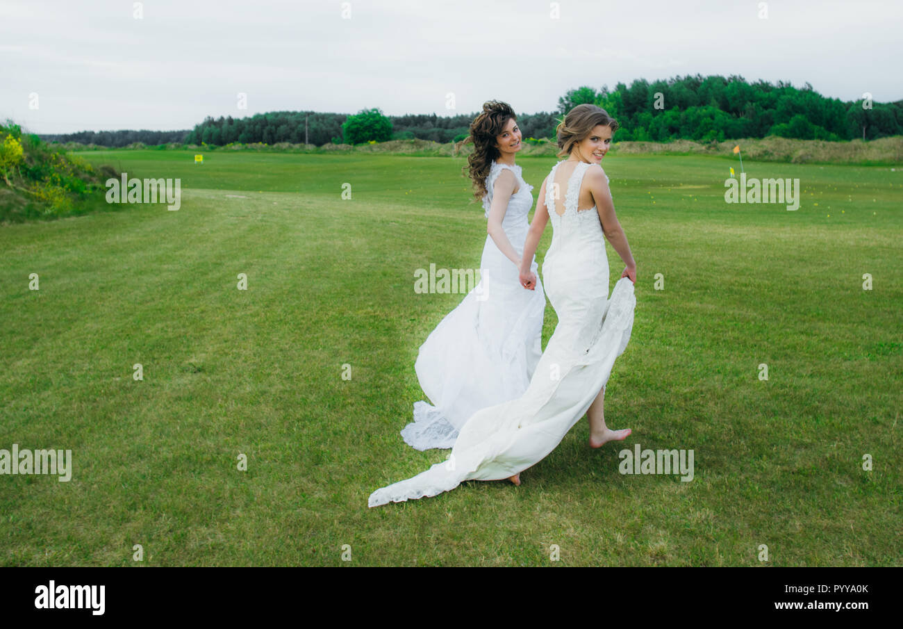 Zwei schöne Bräute zu Fuß auf den grünen Bereich des Golf Club Stockfoto