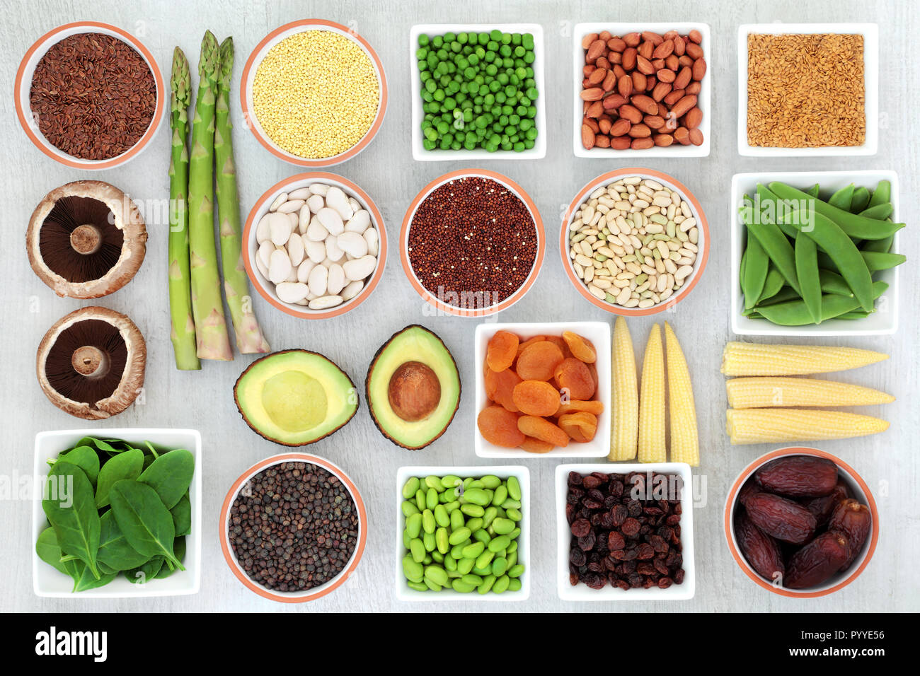 Protein Pflanzenschutz Auswahl an Speisen für eine gesunde Ernährung mit Getreide, Hülsenfrüchte, getrocknete Früchte, Samen, Nüsse und Gemüse auf rustikalem Holz Hintergrund. Lebensmittel h Stockfoto
