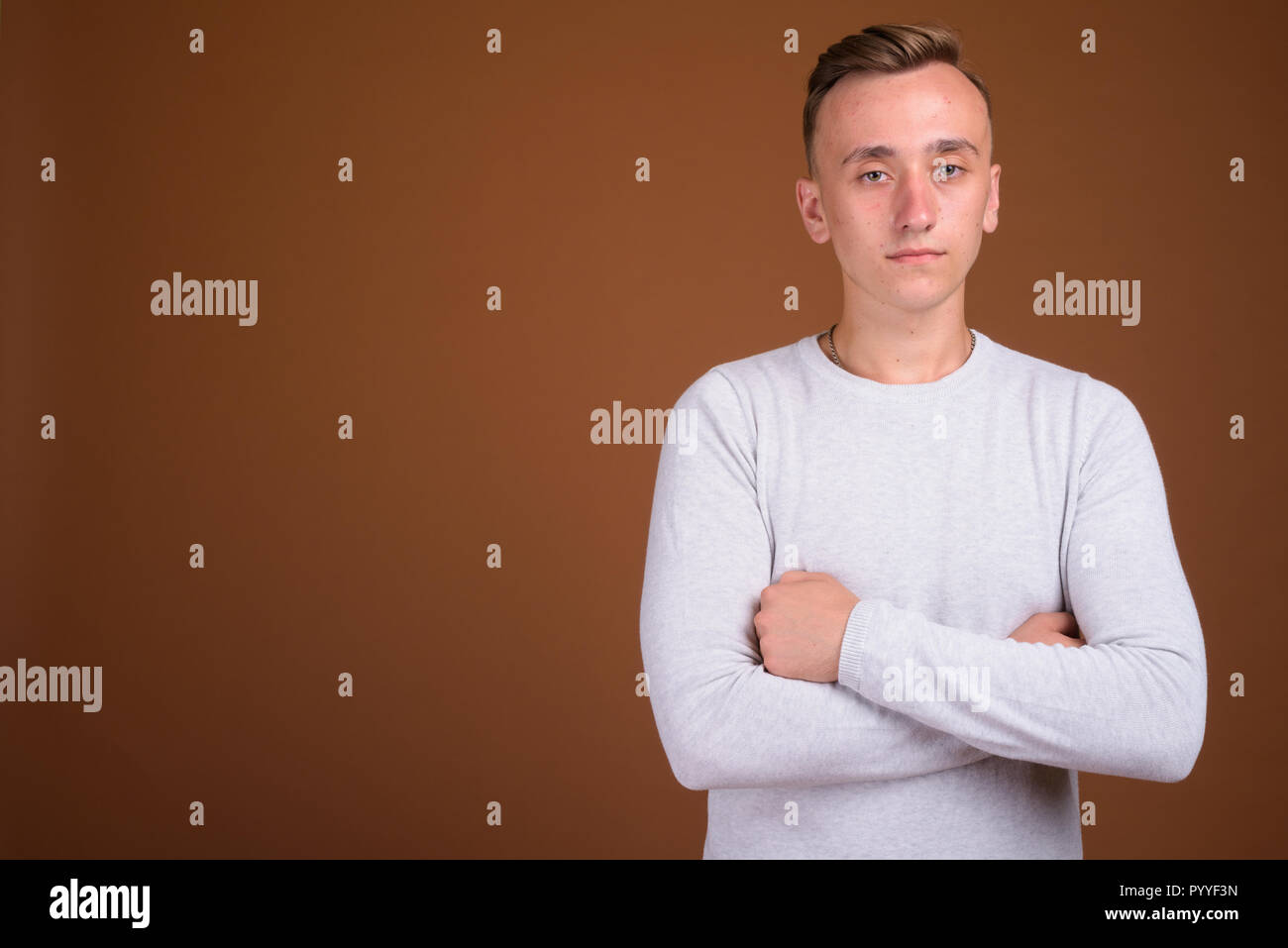 Porträt junger stattlicher Mann mit verschränkten Armen Stockfoto