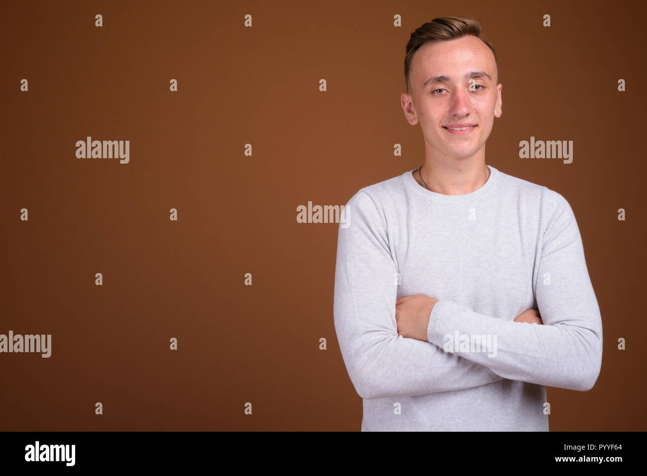 Porträt junger stattlicher Mann mit verschränkten Armen Stockfoto