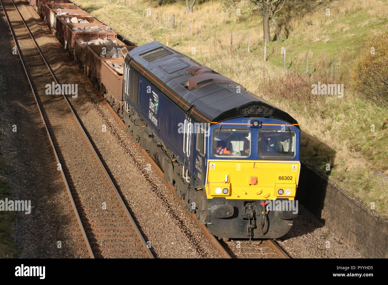 Class 66 diesel-elektrische Lok in DRS livery verlassen Blea Moor Tunnel der Eisenbahnlinie nach Carlisle mit einem Güterzug am 30. Oktober 2018 vereinbaren. Stockfoto