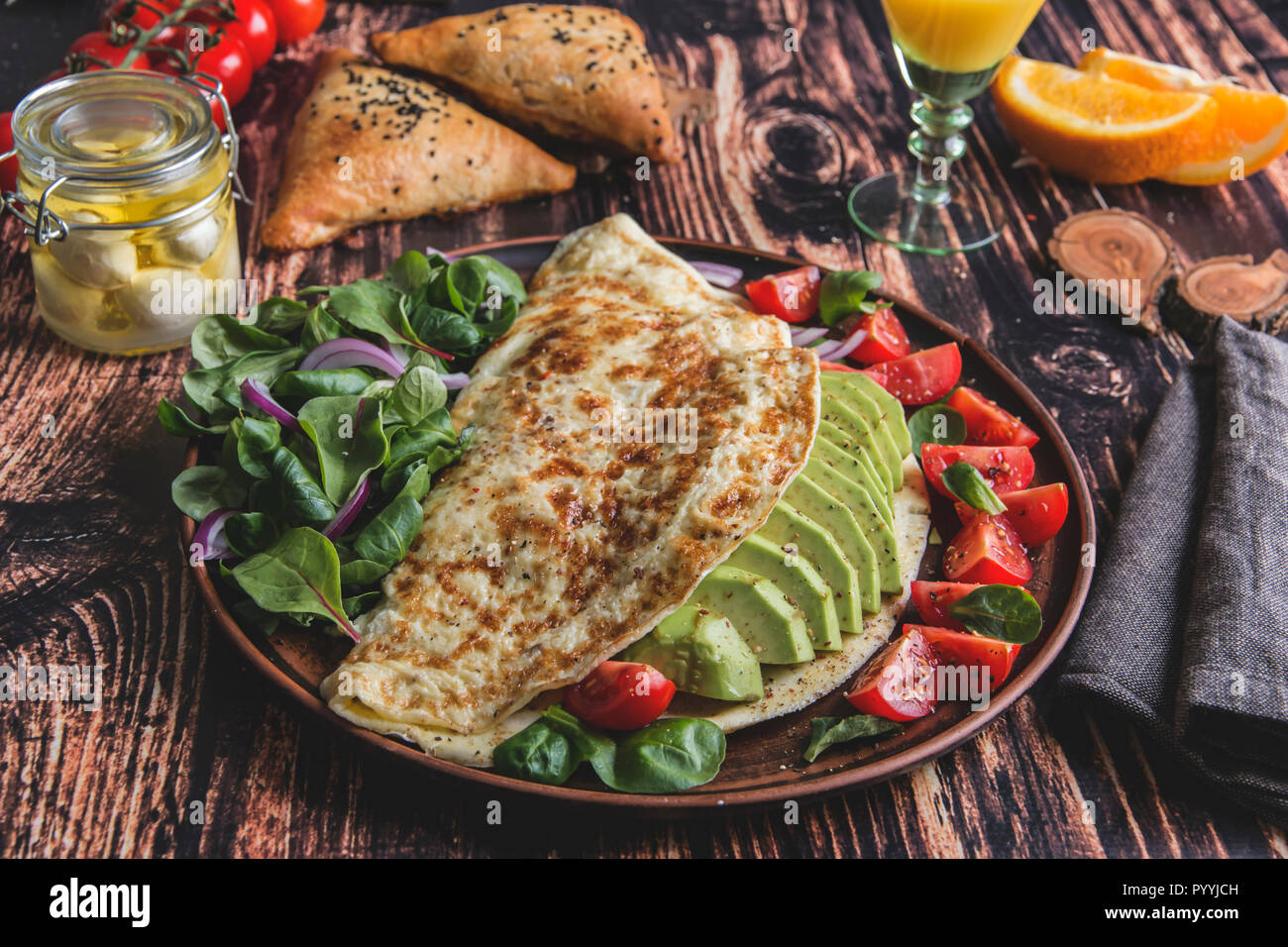 Omelette mit Avocado, Tomate, Mozzarella, Käse, Orangensaft, samsa. Gesunde Ernährung Stockfoto
