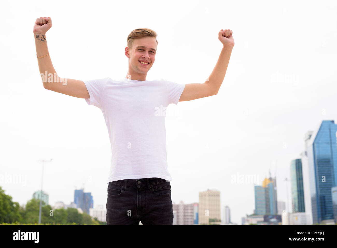 Junger stattlicher Mann mit blonden Haaren Entspannung im Park Stockfoto