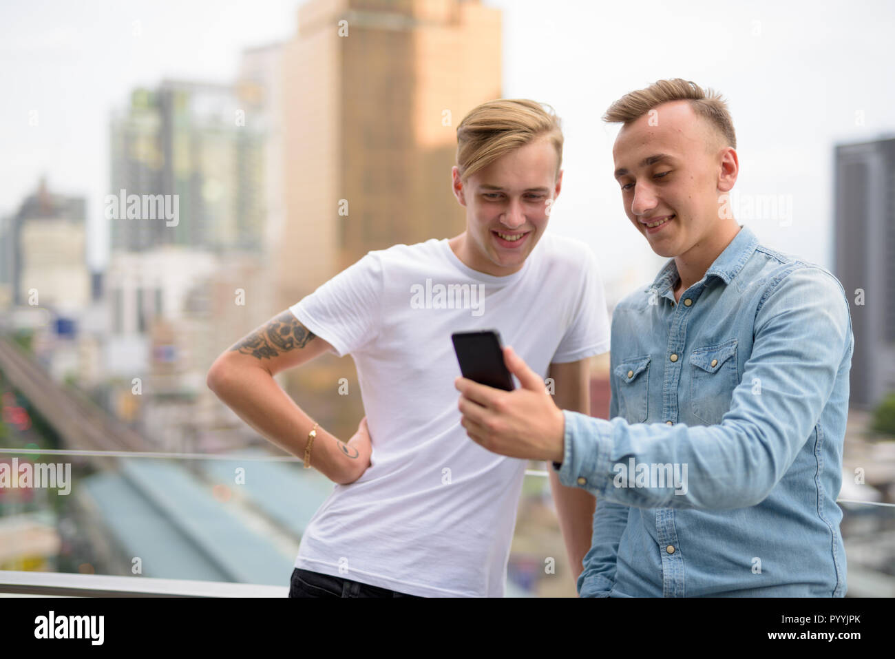 Zwei glückliche Menschen mit Handy im Freien Stockfoto