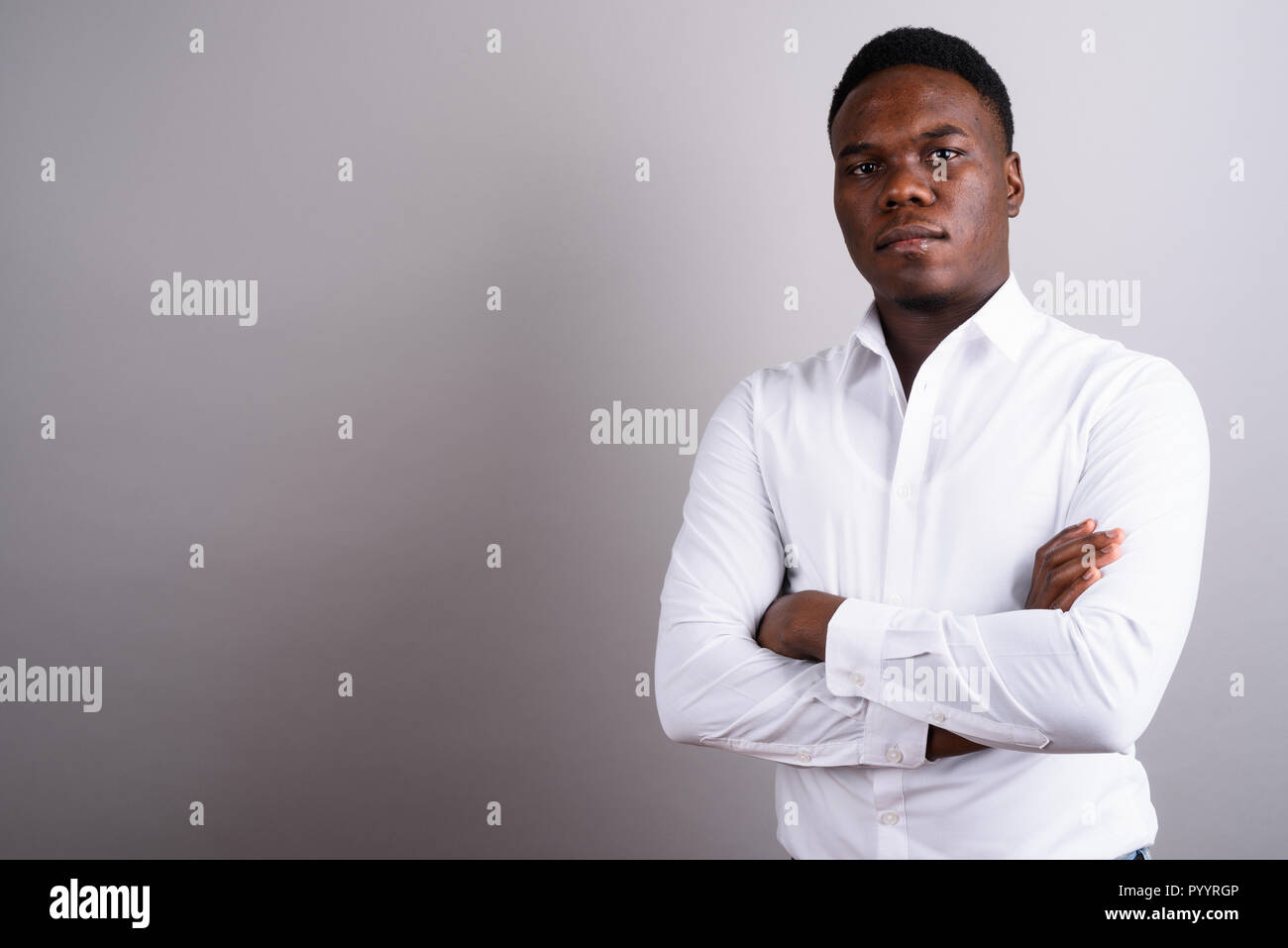Porträt der jungen zuversichtlich Afrikanischen Geschäftsmann mit gekreuzten Armen Stockfoto