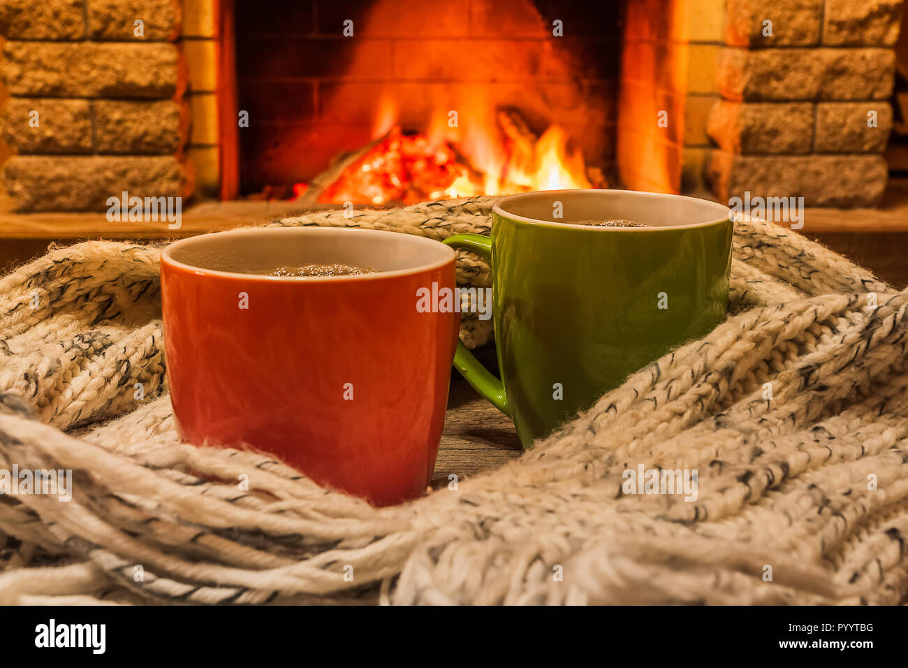 Für zwei Tassen heißen Tee oder Kaffee und gemütlich warmen Schal in der Nähe von Kamin, im Landhaus, winter Urlaub, horizontal. Stockfoto