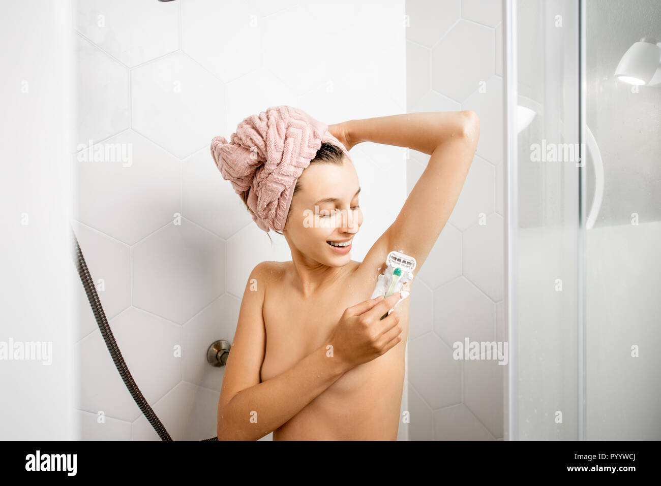 Frau rasieren Ihr Unterarm nach der ständigen im weißen Duschkabine Dusche Stockfoto