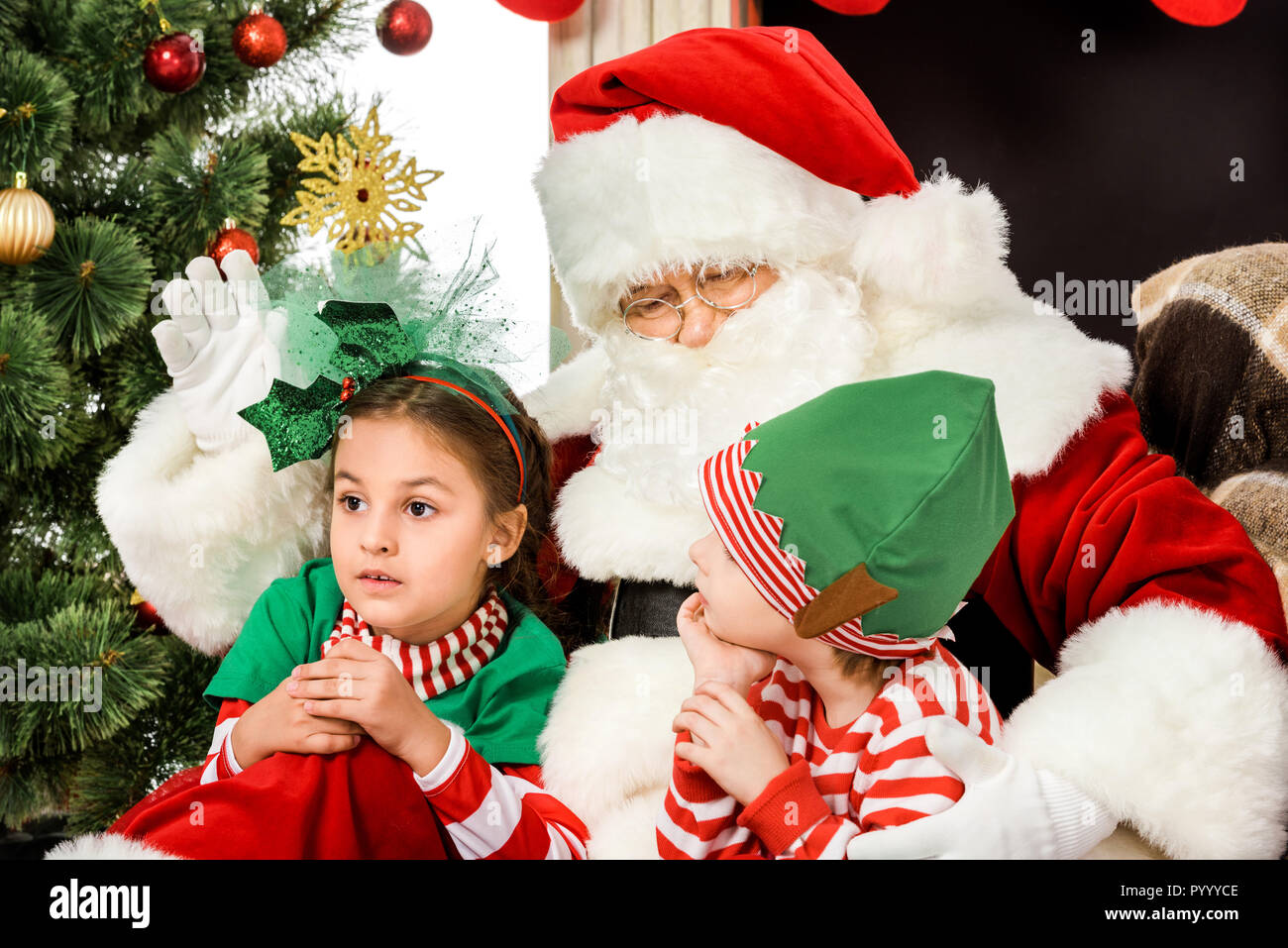 Nahaufnahme von Santa Kinder umarmen und winkt für Kamera Stockfoto