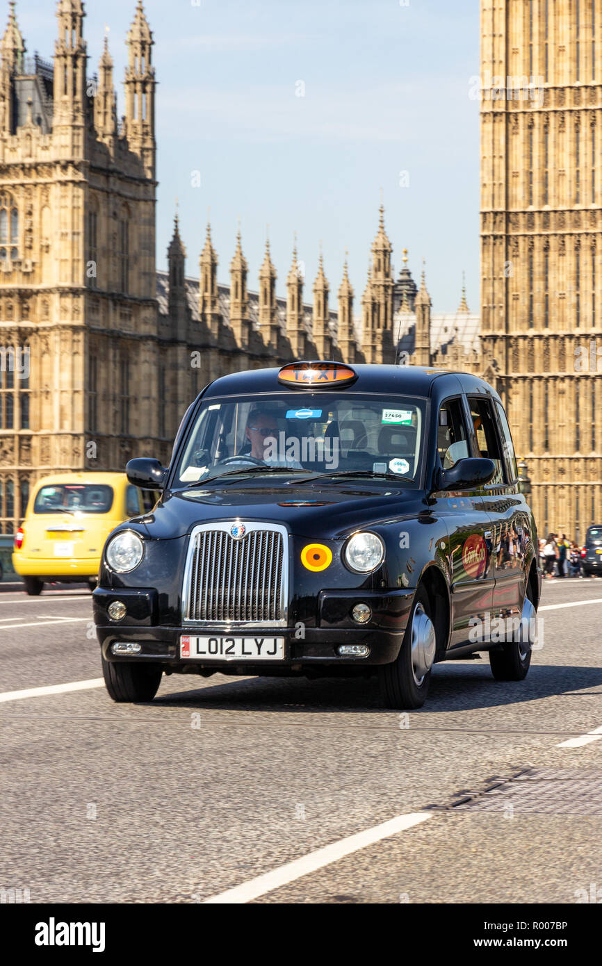 LONDON - Apr 1, 2015: Schwarz Taxi über die Westminster Bridge in der Nähe von Big Ben in London fahren. Stockfoto