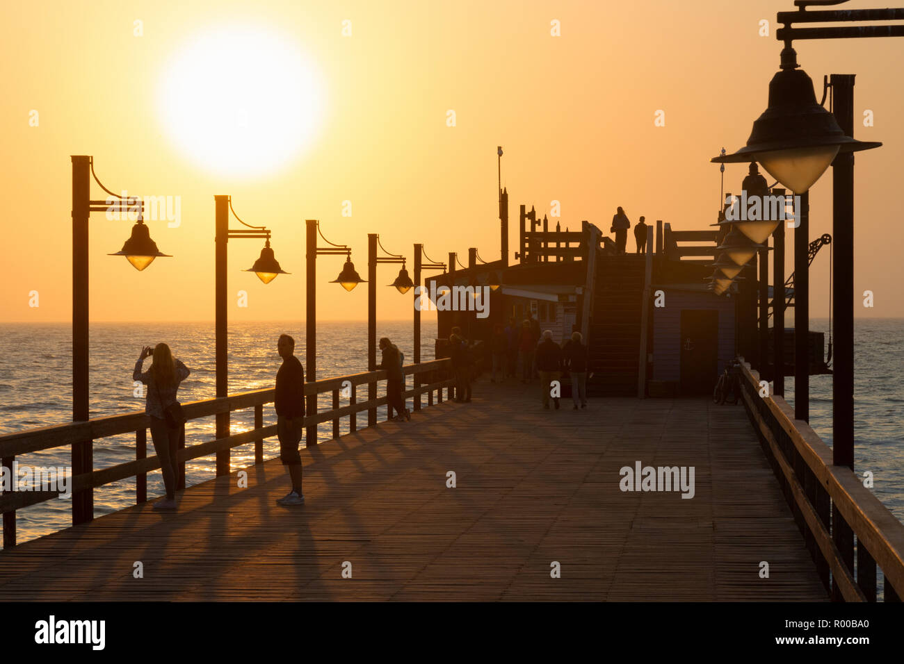 Namibia Sonnenuntergang - Touristen auf dem Steg, Swakopmund, Namibia Afrika Stockfoto