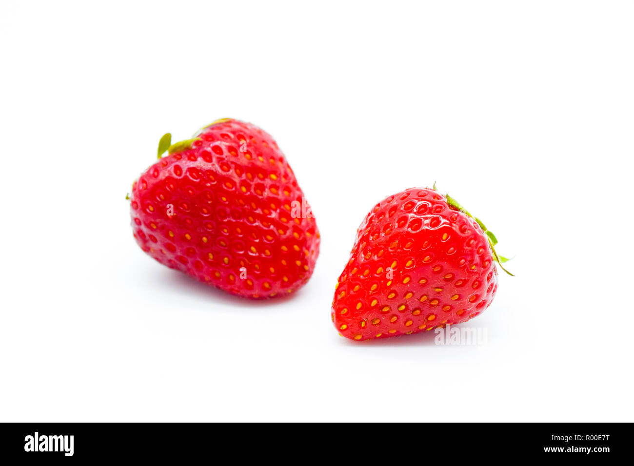 Zwei ganze Erdbeeren auf weißem Hintergrund Stockfoto