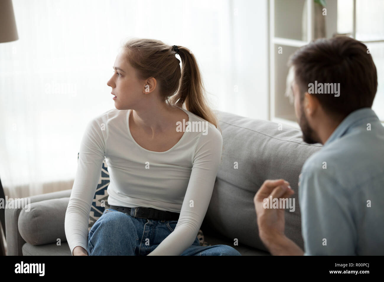 Frau und Mann in sich zerstrittenen Sitzen auf der Couch zu Hause Stockfoto