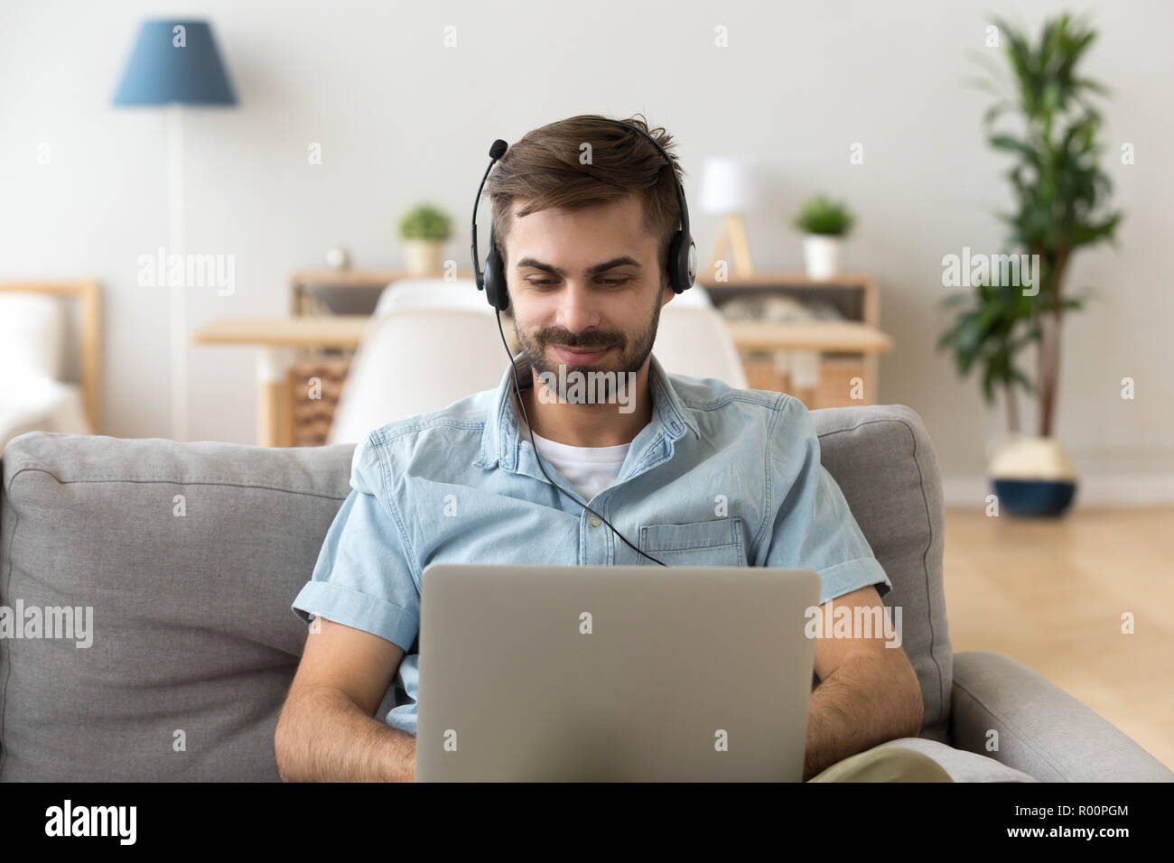 Mann mit Headset und Laptop arbeiten Studium zu Hause Stockfoto