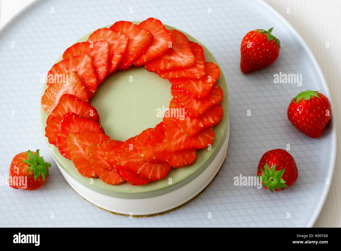 Kochen Demo. Nein - Backen zweischichtige Mini Erdbeere matcha Käsekuchen. Erdbeere Schichten schmücken die Oberseite des Kuchens. 3 Tassen mit Kaffee, Plätzchen und s Stockfoto