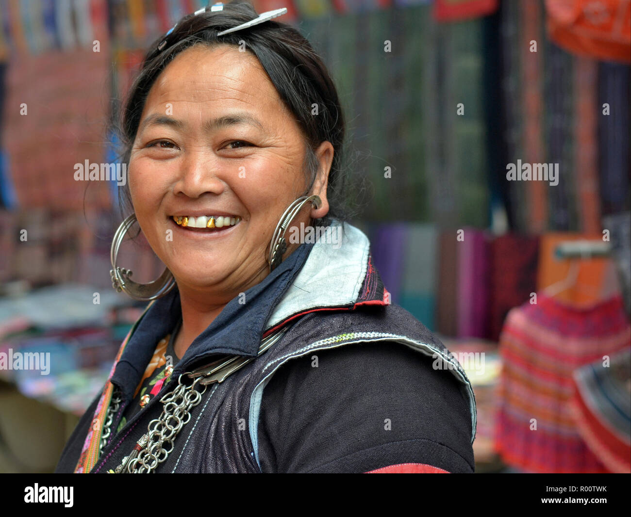 Full-gemustert, im mittleren Alter Vietnamesischen schwarzen H'mong Bergvolk Frau mit großen silbernen Ohrringe und drei Gold Zähnen Lächeln für die Kamera. Stockfoto