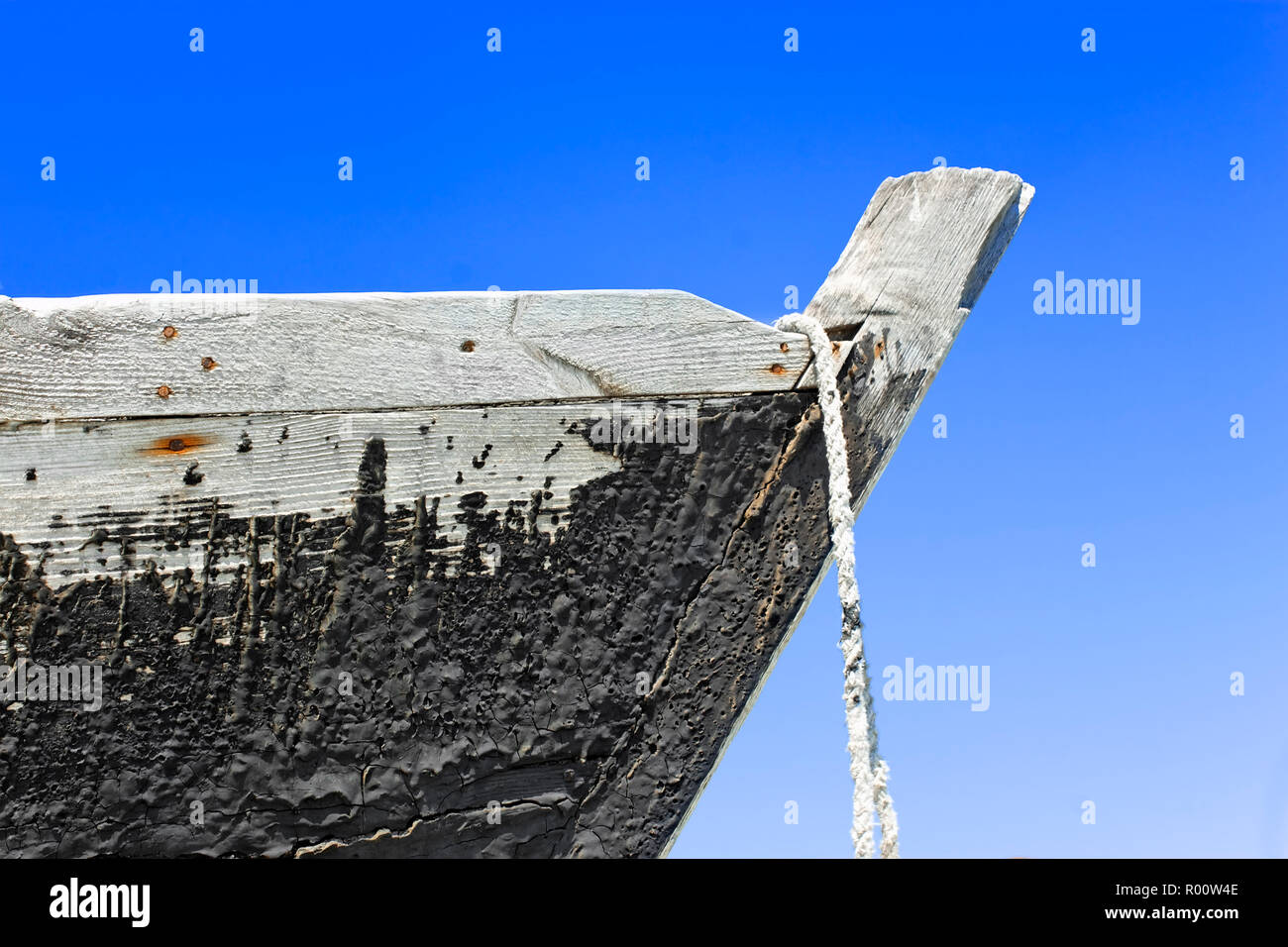 Der Bug des alten hölzernen Boot mit einem Geteerten Fläche gegen den blauen Himmel Stockfoto