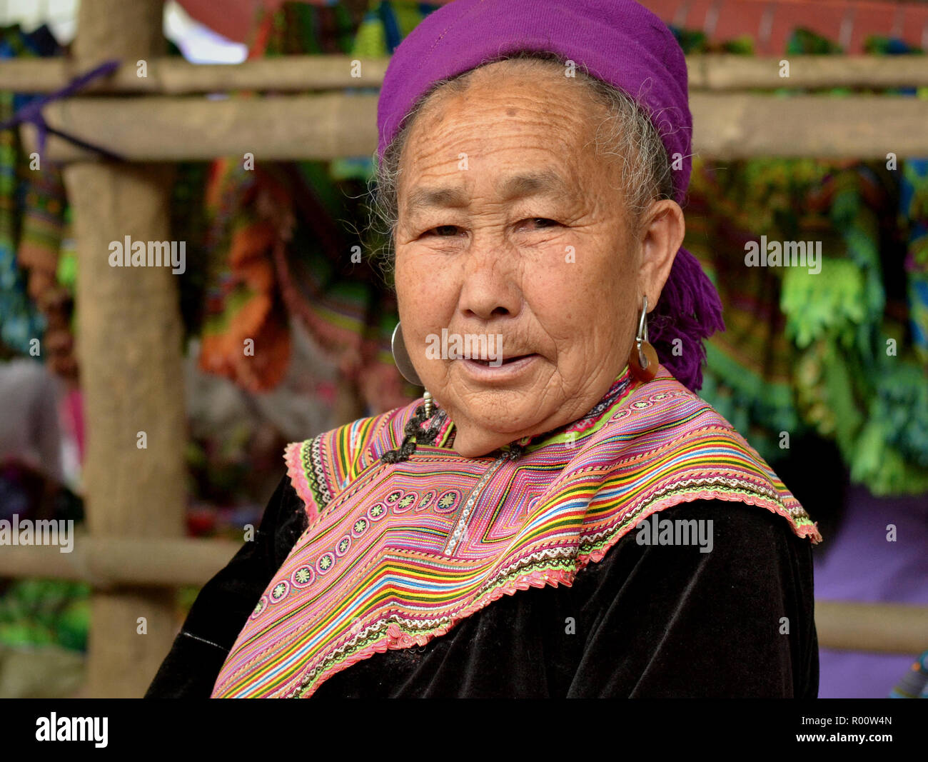 Alte Vietnamesische schwarzen H'mong Markt Frau trägt Traditionelle bestickte Kleidung und posiert für die Kamera. Stockfoto