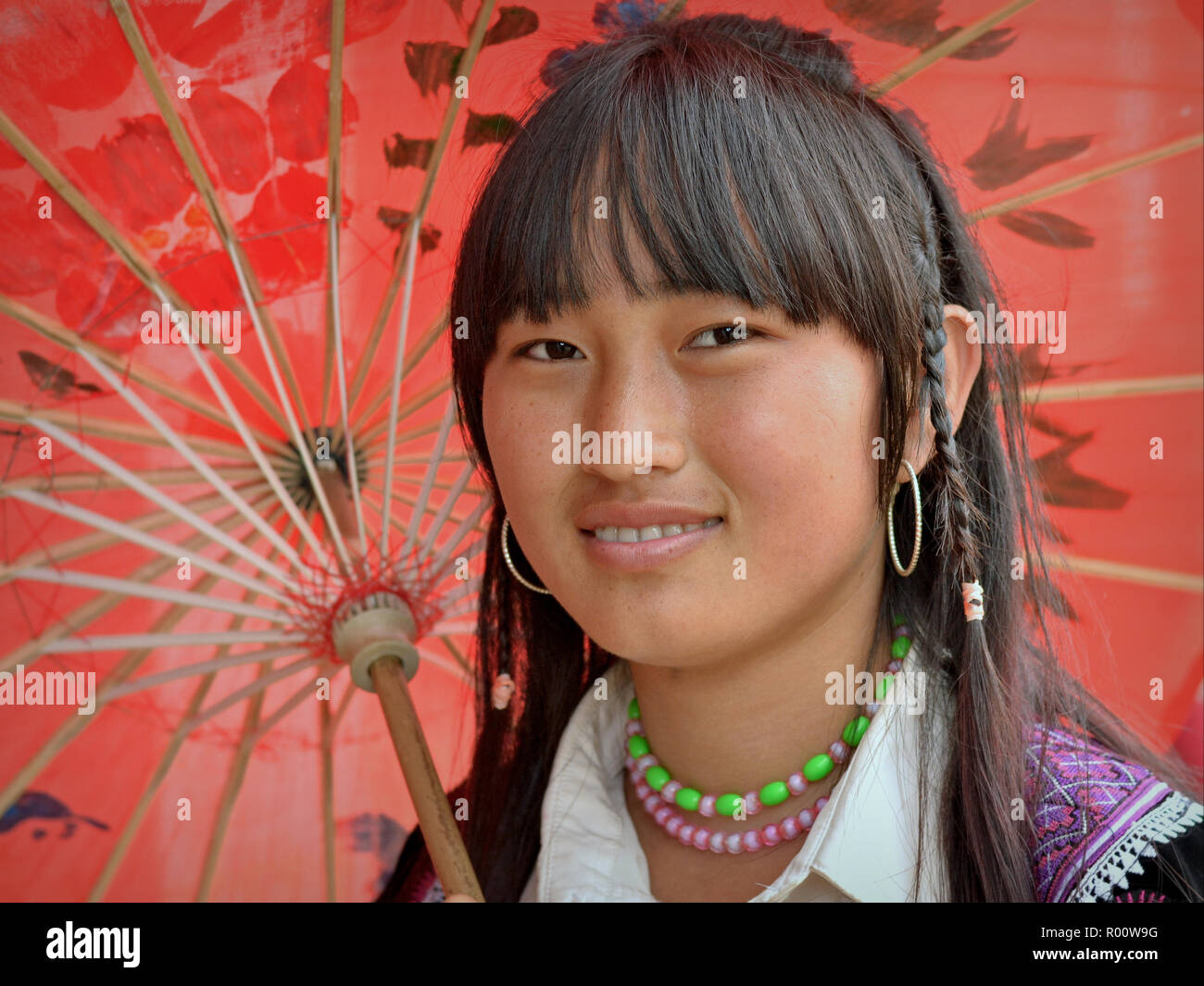 Vietnamesische H'Mong Jugendmädchen stellt unter einem handgefertigten traditionellen Öl- papier Sonnenschirm. Stockfoto
