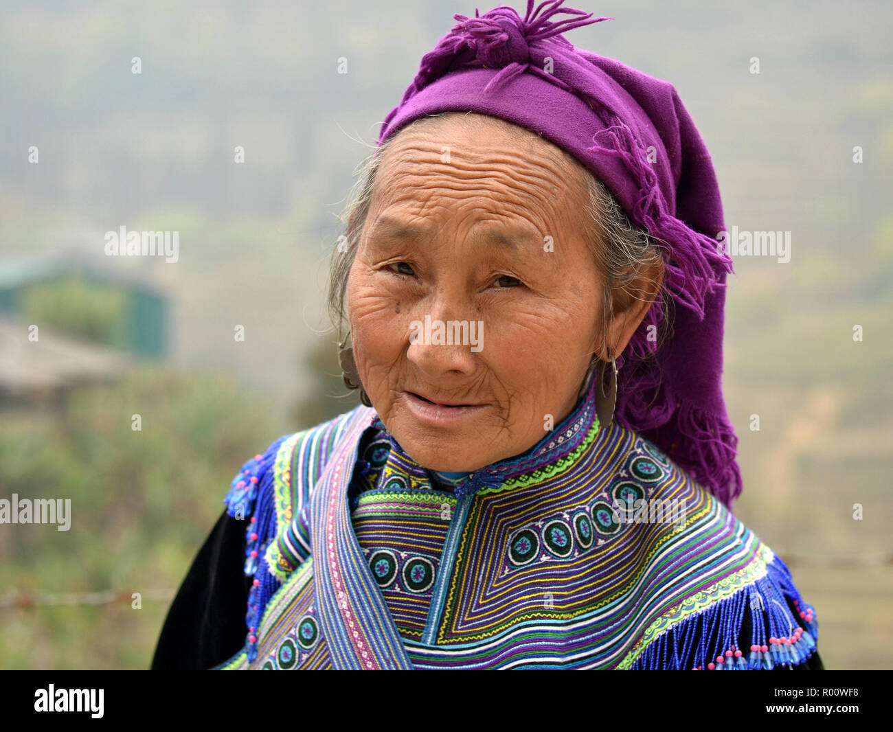 Alte vietnamesische H'Mong ethnische Minderheit Bergvolk Frau trägt bestickt traditionelle H'Mong Kleidung und sieht in die Kamera. Stockfoto