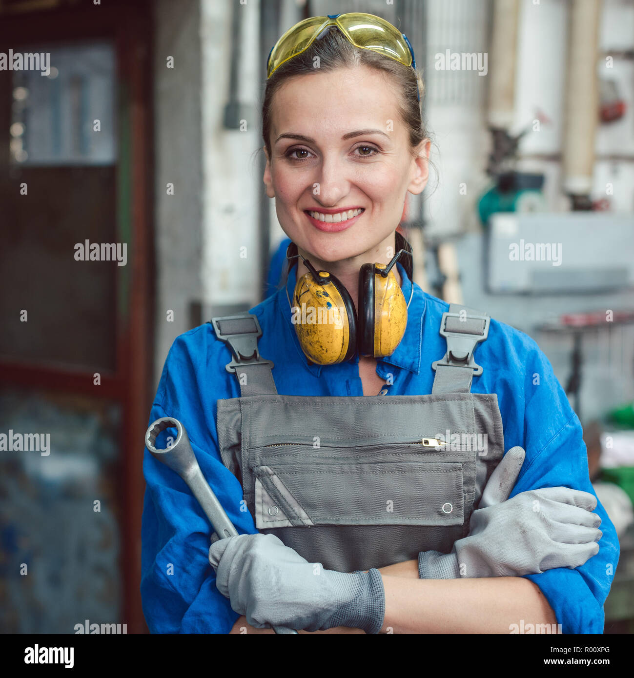 Arbeiterin in der Metallwerkstatt mit Tools posing Stockfoto