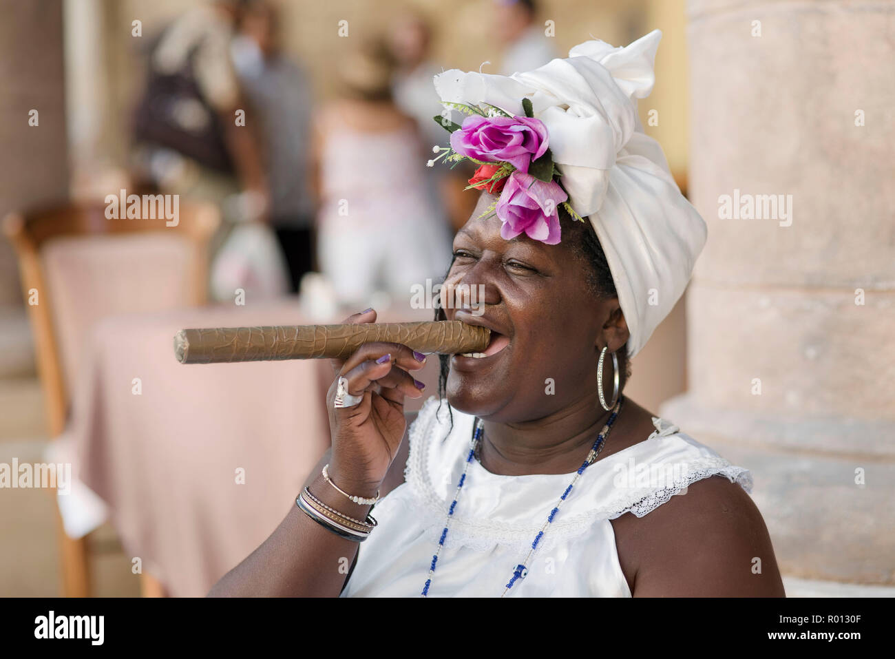 Theresa, eine fortunte Erzähler, stellt mit einem riesigen kubanische Zigarre und einem ansteckenden Lächeln in einer Plaza in Havanna. Stockfoto
