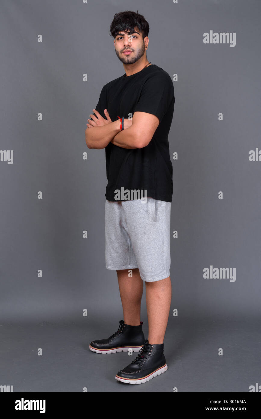 Junge schöne Indische Mann gegen grauer Hintergrund Stockfoto