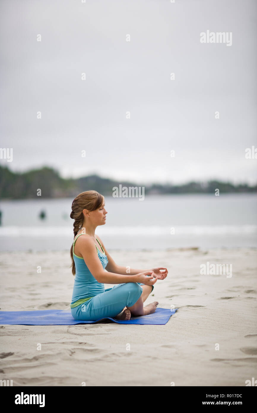 Junge erwachsene Frau, meditieren und Yoga auf einer Veranda. Stockfoto