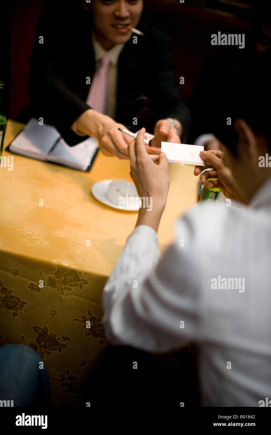 Hand, die eine Visitenkarte und eine Zigarette. Stockfoto